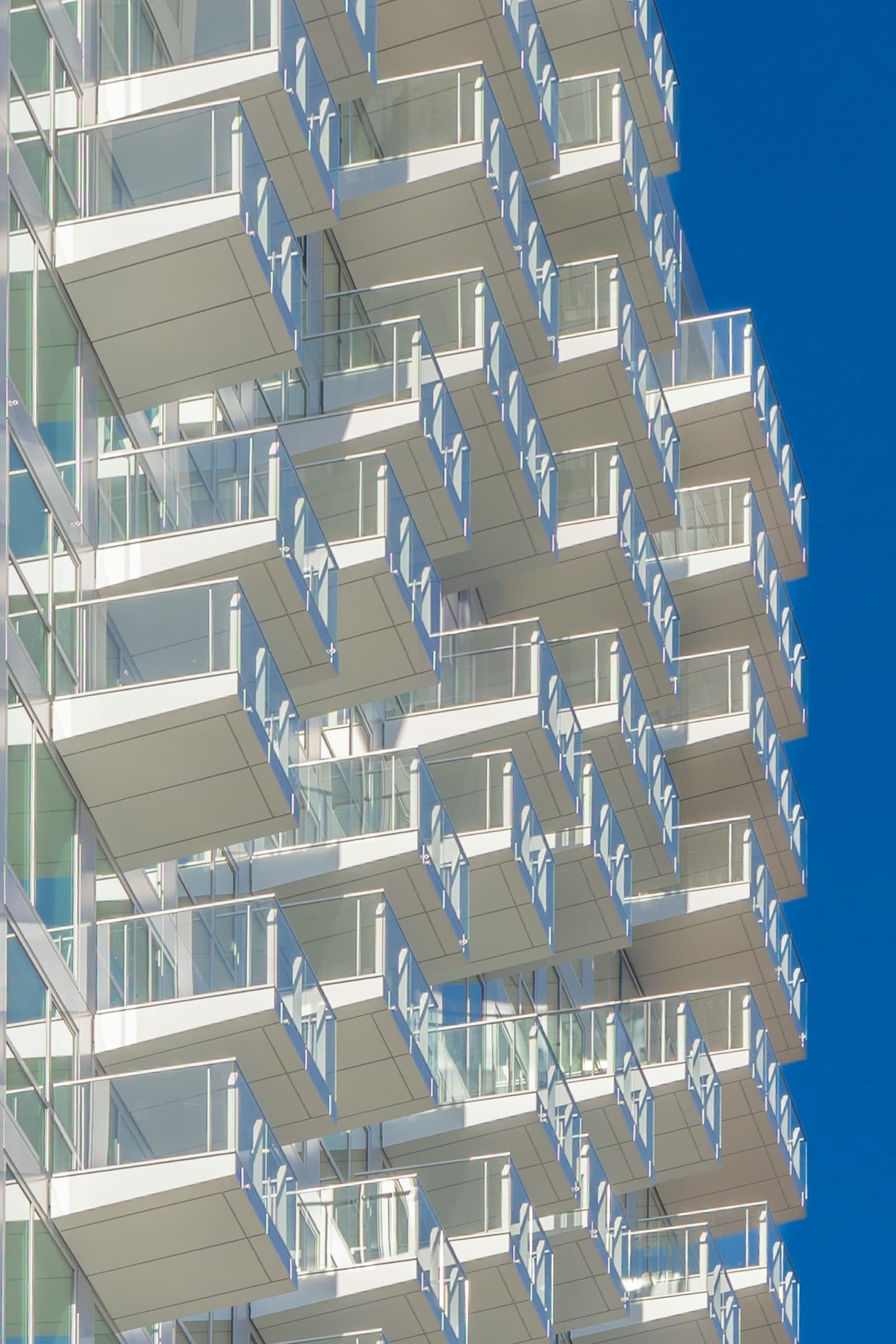 Blue and white apartment block facade against clear sky